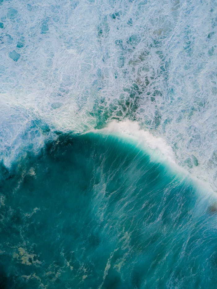 Stunning aerial shot of turquoise ocean waves crashing in Tamarama, NSW.